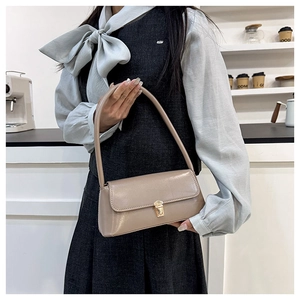 Chic beige faux leather baguette shoulder bag with elegant gold metal clasp detail