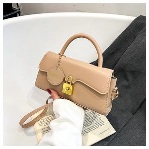 Detail of light brown vintage leather crossbody bag with golden buckle and fashion charm