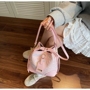 Dettaglio della borsa a secchiello rosa con texture a rilievo e cuciture a onde colorate