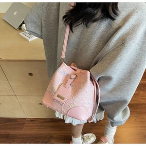 Dettaglio della borsa a secchiello rosa con ricami colorati e chiusura a coulisse