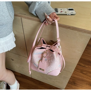 Dettaglio della borsa a secchiello rosa con ricami ondulati colorati e chiusura a cordoncino