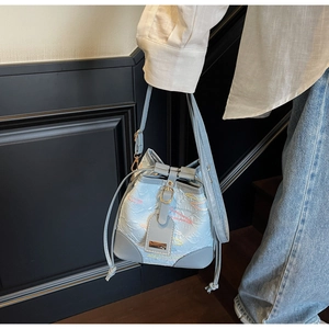 Dettaglio borsa a secchiello azzurra con ricamo a onde colorate e chiusura a coulisse in pelle