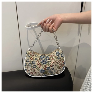 Détail du sac en jacquard floral avec nœud argenté et finitions en cuir blanc élégantes