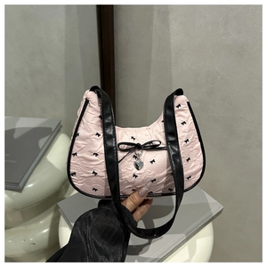 Macro view of pink baguette bag with black bow prints and silver heart charm