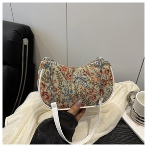 Détail de broderies florales et chaîne nœud argenté sur le sac à bandoulière demi-lune