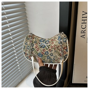 Vue détaillée du sac baguette à fleurs vintage avec chaîne et nœud argenté