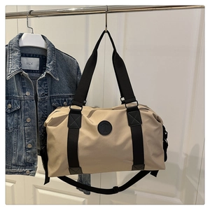 Detail of minimalist beige oxford gym bag with adjustable strap hanging in a stylish setting