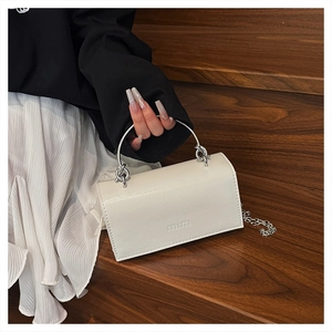 Gros plan du sac bandoulière en cuir blanc avec poignée chaîne argentée et logo mim