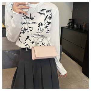 Détail du sac bandoulière rose en cuir verni brillant avec poignée et chaîne argentée
