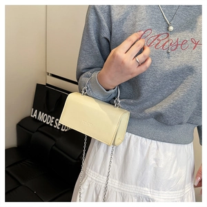 Petit sac bandoulière jaune avec poignée ronde argentée et chaîne porté par un mannequin