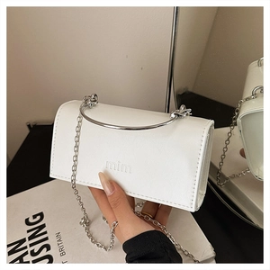 Détail du mini sac en cuir blanc avec poignée ronde en argent et logo mim