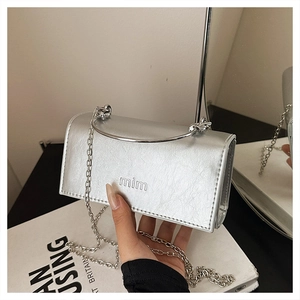 Gros plan détaillé du mini sac argenté métallisé avec poignée anneau et chaîne