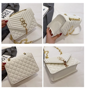 Close-up of white quilted crossbody bag with gold chain, tassel, and metallic logo hardware
