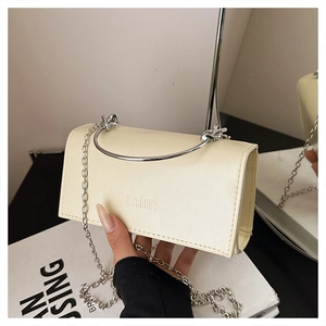 Détail du mini sac crème avec poignée anneau argentée et bandoulière chaîne