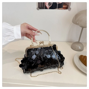 Détail du sac de soirée à paillettes noires avec poignée en métal doré et bandoulière