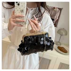 Detail of black sequins evening bag with vintage gold handle and metallic chain strap