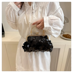 Détail de la pochette à paillettes noires avec poignée dorée et bandoulière chaîne