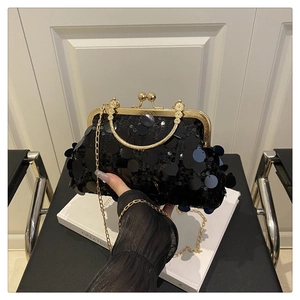 Détail du sac de soirée à paillettes noires avec poignée dorée et bandoulière chaîne