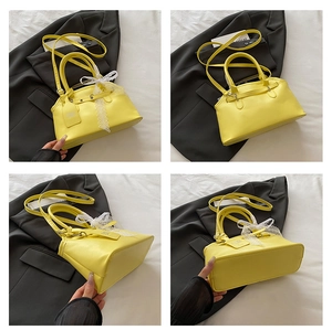 Detail view of yellow shell-shaped handbag showing lace bow and adjustable strap