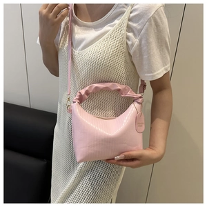 Detail of pink pleated cloud bag with glossy vertical stripes and slim shoulder strap