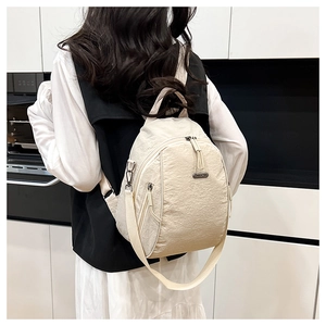 Close-up of lightweight off-white nylon backpack with adjustable straps and zip pockets