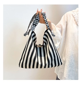 Detail of black and white striped canvas tote bag with geometric patterned knot handle