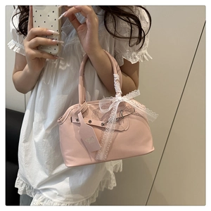 Détail du sac coquillage vintage rose avec nœud en dentelle blanche et boucle ajustable