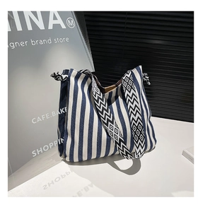 Detail of blue and white striped canvas tote bag with geometric patterned wide strap