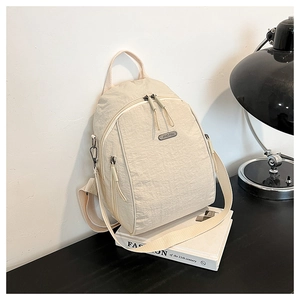 Detail of off-white backpack with pleated fabric texture and functional side zipper pocket