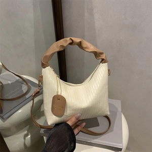 Minimalist ruched cloud bag with white pleated texture and contrast brown handle
