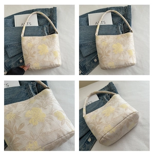 Close-up of elegant floral embroidery and relief texture on beige tote bag