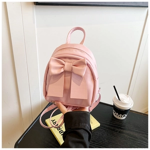 Detailed view of pink mini backpack with large bow decoration and adjustable straps