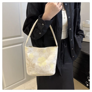 Macro detail of high-quality floral jacquard fabric on elegant cream white tote bag