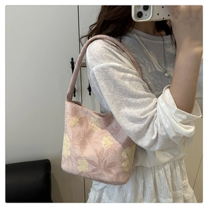 Detail view of pink floral canvas tote bag with yellow flowers and shoulder strap