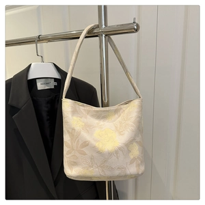 Close-up of beige floral jacquard tote bag showing elegant flower texture and fabric