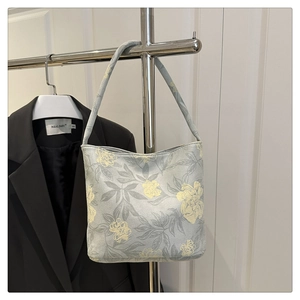 Detailed texture of jacquard fabric tote bag with yellow floral patterns on light blue