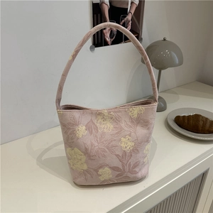 Elegant Chinese style handbag with pink floral pattern and thick top handle in room setting