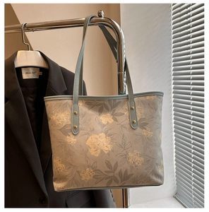 Détail du sac cabas bleu clair avec motifs floraux vintage sur cuir de qualité
