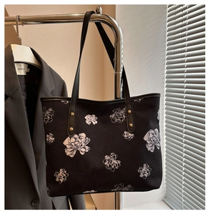 Vue détaillée du grand sac cabas noir à motifs floraux blancs et rivets dorés en métal