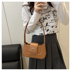 Détail d'un sac à main en cuir PU camel avec un fermoir nœud métallique élégant et chic
