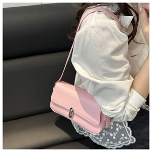 Detail of a pink baguette bag with a silver oval metal twist lock and smooth texture
