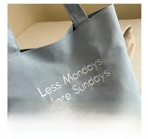 Detailed shot of vintage canvas tote bag with Less Mondays More Sundays embroidery
