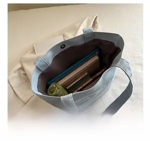 Interior view of denim tote bag showing large capacity for books and tablet with magnetic clasp