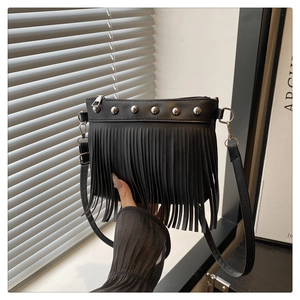 Dettaglio della borsa a tracolla nera in pelle PU con rivetti metallici e frange lunghe