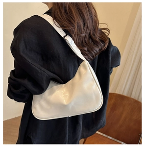 Chic cream white leather shoulder bag with glossy finish shown worn on model