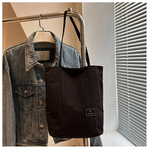 Detail of black tote bag brand label with a casual texture and oversized stylish design