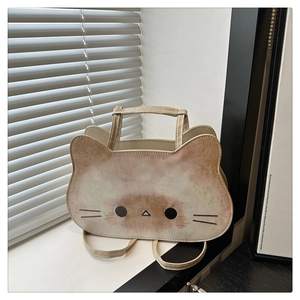 Detail of the cute cat-shaped tote bag showing textured leather and cartoon face printing