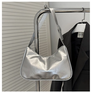 Detail of silver pleated hobo bag with metallic finish texture and adjustable shoulder strap