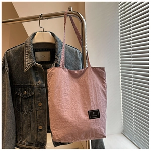 Close-up of pink nylon shoulder bag showing wrinkled texture and Fanvissa brand label