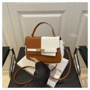 Detail of color-block saddle bag with brown and white PU leather and golden lock
